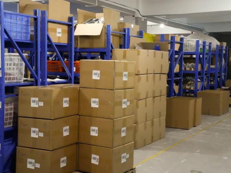 Stacked-cardboard-boxes-and-blue-storage-racks-in-finished-goods-warehouse.jpg