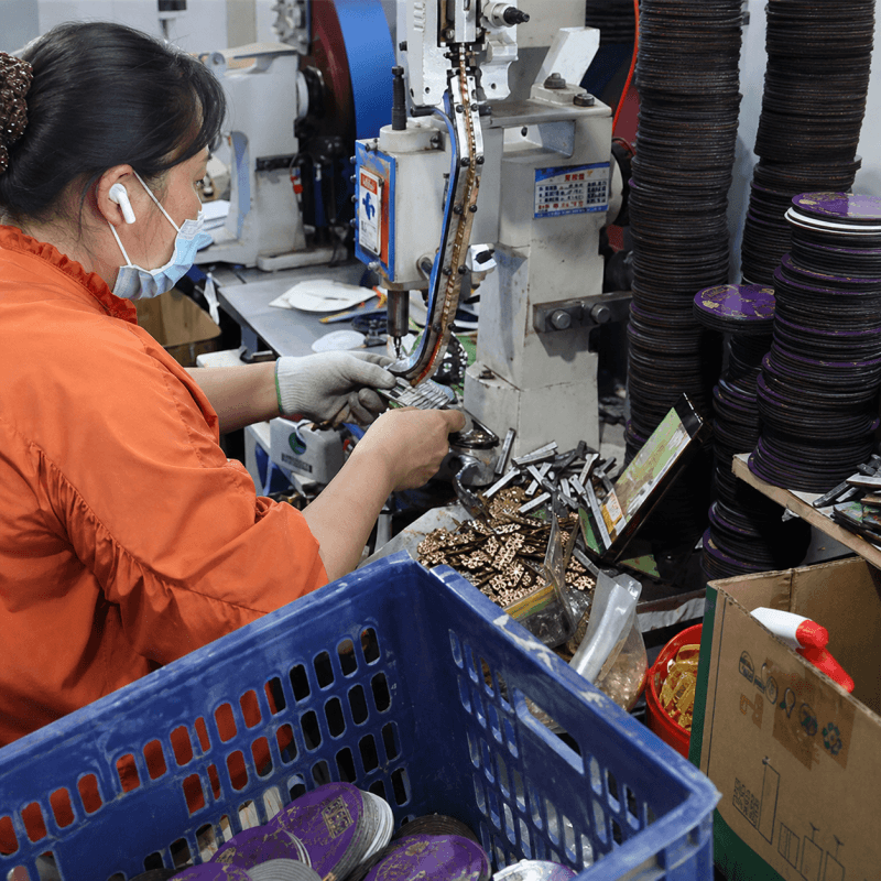 Worker Assembling Magnets on Riveting Machine