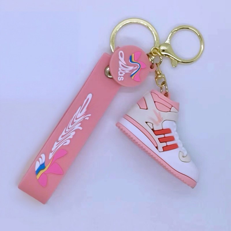 Adidas shoe keychain on a pink printed tag strap with a pink and white mini sneaker and gold-tone ring