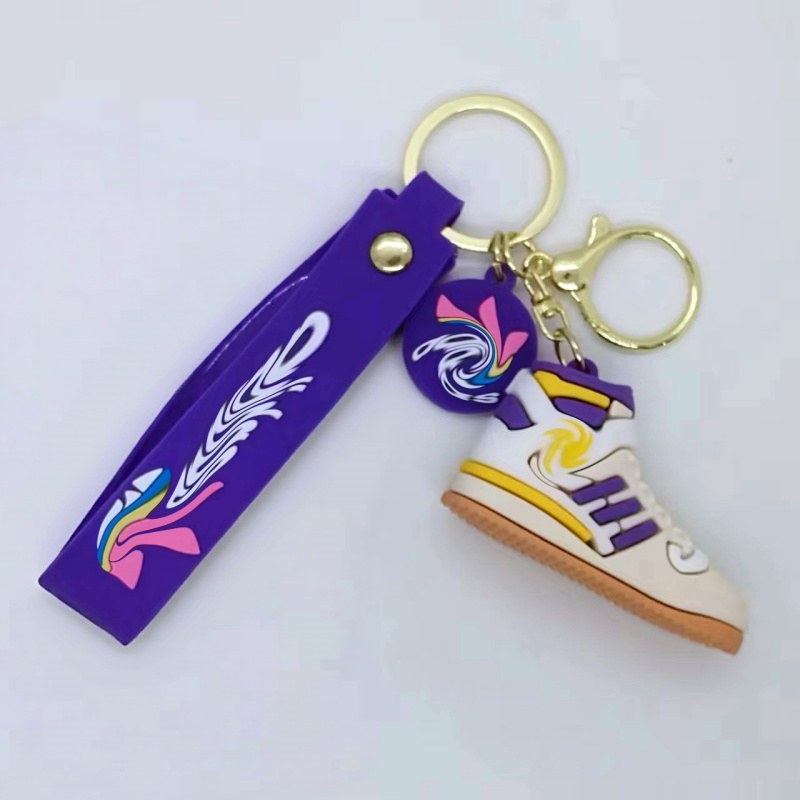 Adidas shoe keychain on a purple printed tag strap with a purple, white and yellow mini sneaker
