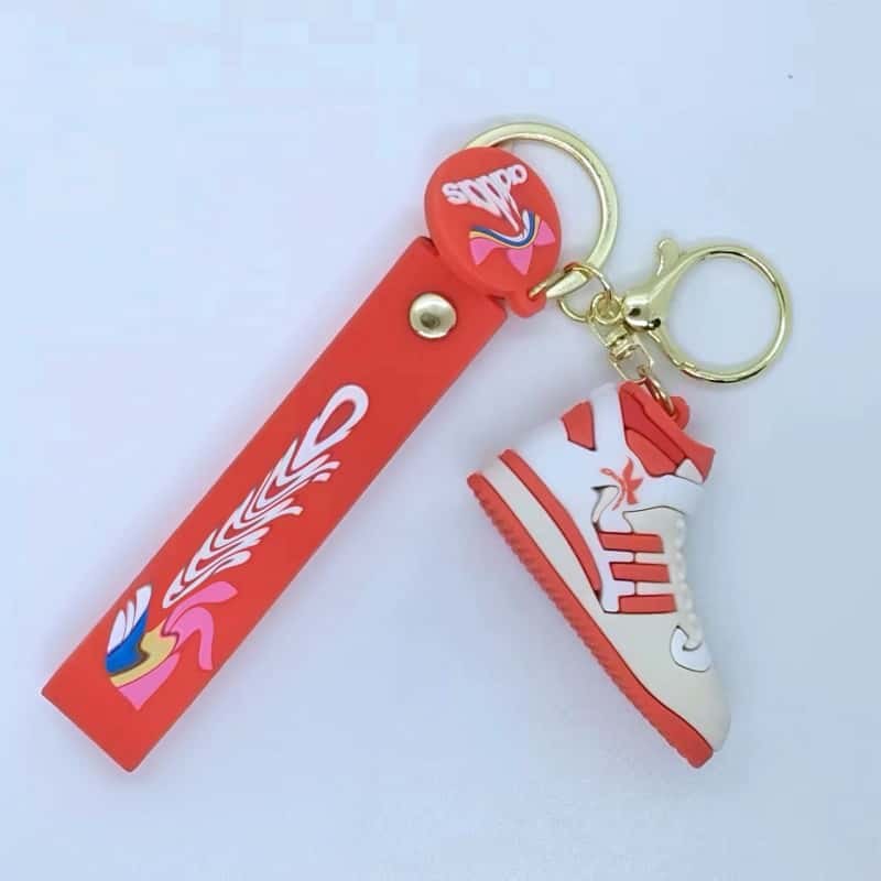 Adidas shoe keychain on a red printed tag strap with a red and white mini sneaker on a gold-tone ring