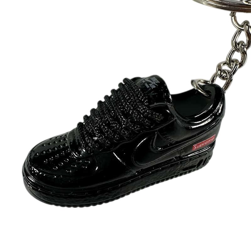 Air Force One shoe keychain in black PVC, showing the low-top shape, perforated toe cap and flat sole