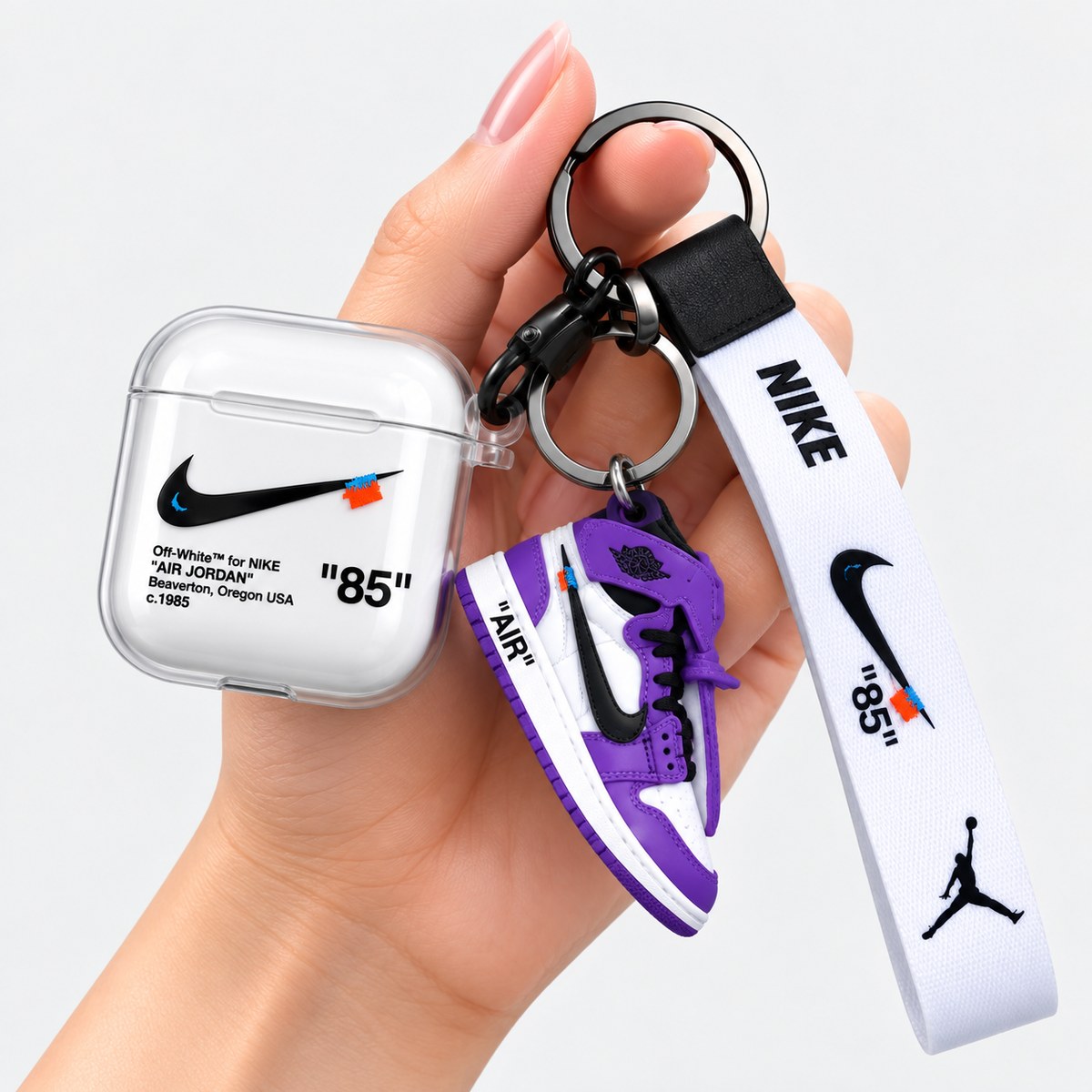 Hand holding airpod case with shoe keychain in assorted colors before packing
