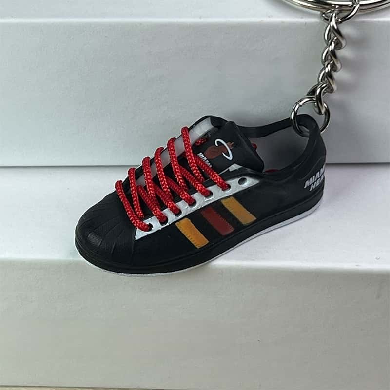 Basketball shoe keychain in black, red and yellow with red laces and a striped side panel, on its chain