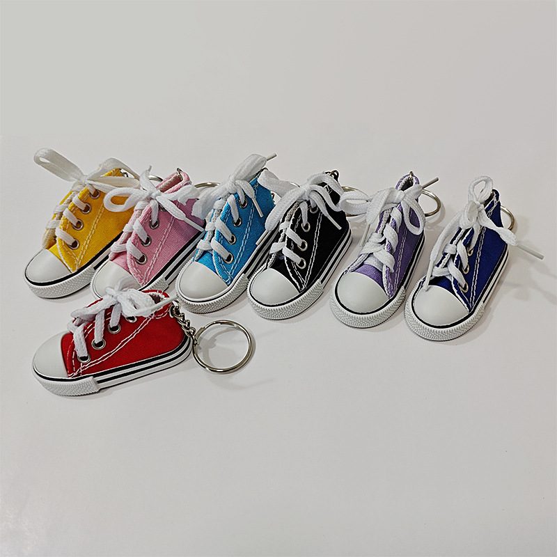 Seven mini canvas shoe keychains in different colors lined up for color selection