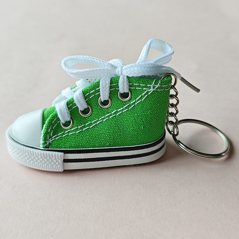 Green mini canvas shoe keychain with a stitched canvas upper and white laces