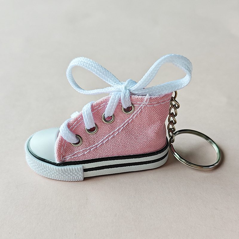 Pink mini canvas shoe keychain with white laces, metal eyelets and a silver split ring