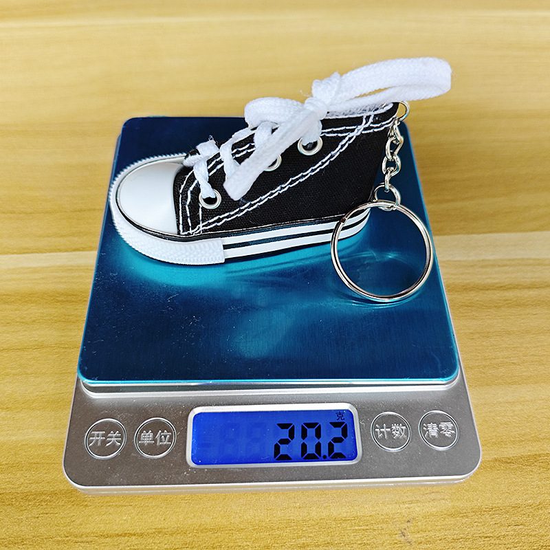 Black mini canvas shoe keychain on a digital scale reading 20.2 grams