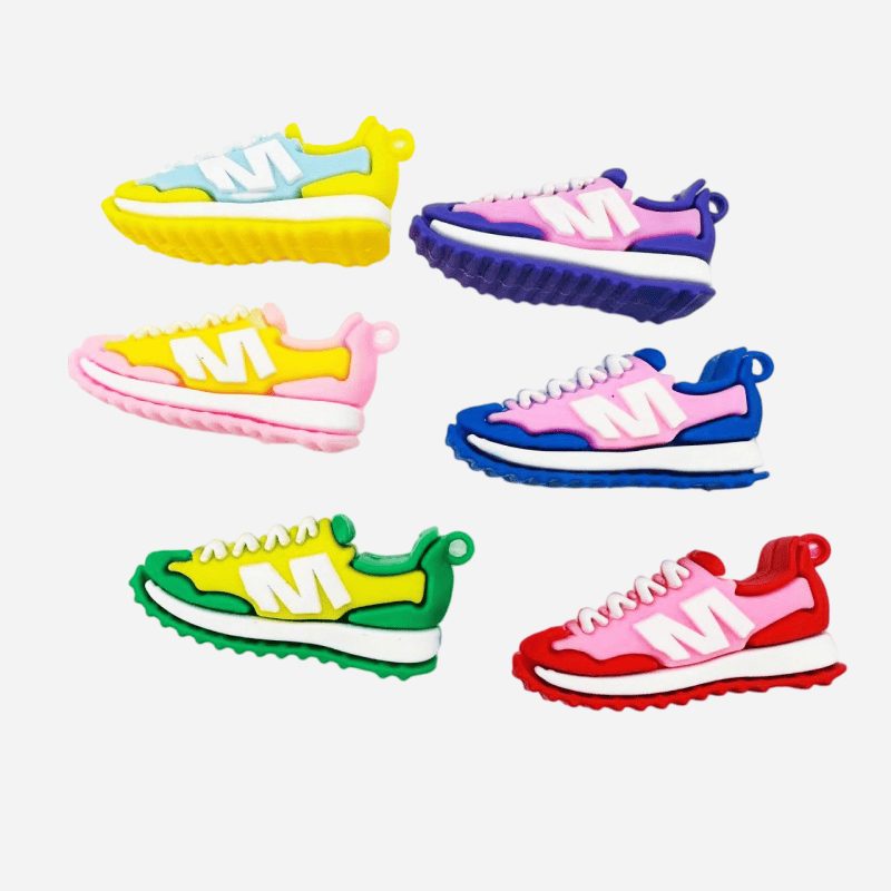 PVC sneaker keychains angled to show both sidewalls and the molded letter M