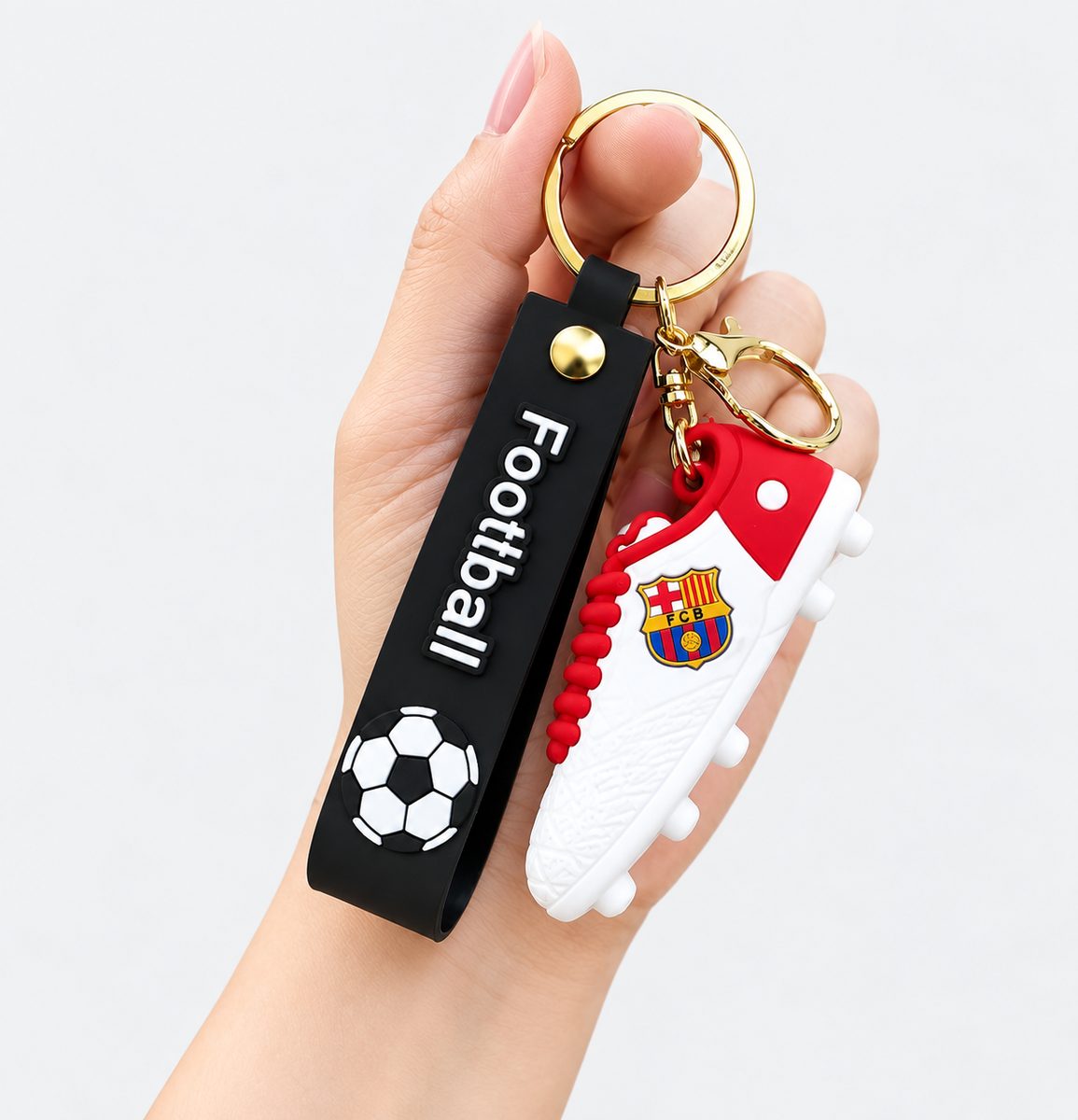 Red and white football boot keychain with black football strap and gold key ring