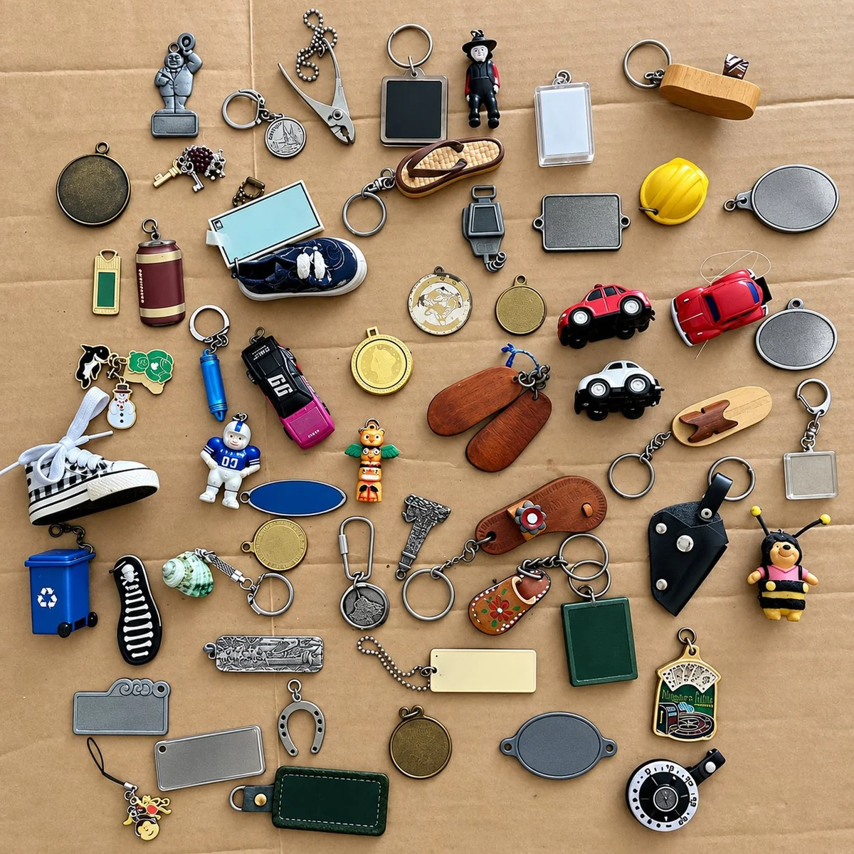Brown cardboard flat-lay of assorted PVC keychains — a small Statue of Liberty figure