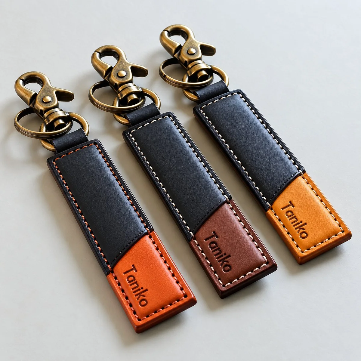 Taniko leather keychain tabs — three two-tone leather fobs in dark navy