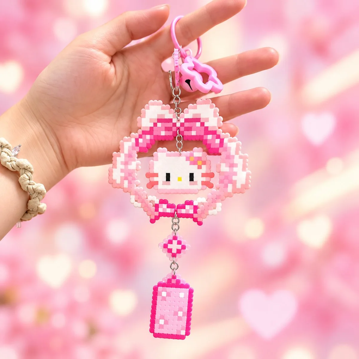 Pixel heart keychain: a Hello Kitty design in pink fused plastic beads hanging from a pink lobster clasp.