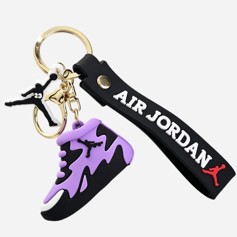 Jordan keychain in purple and black with a splash pattern across the upper, shown with its riveted strap and cast charm