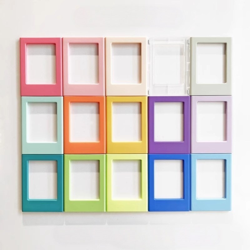 Magnetic picture frames in twenty-four colours arranged in a grid on a plain white wall
