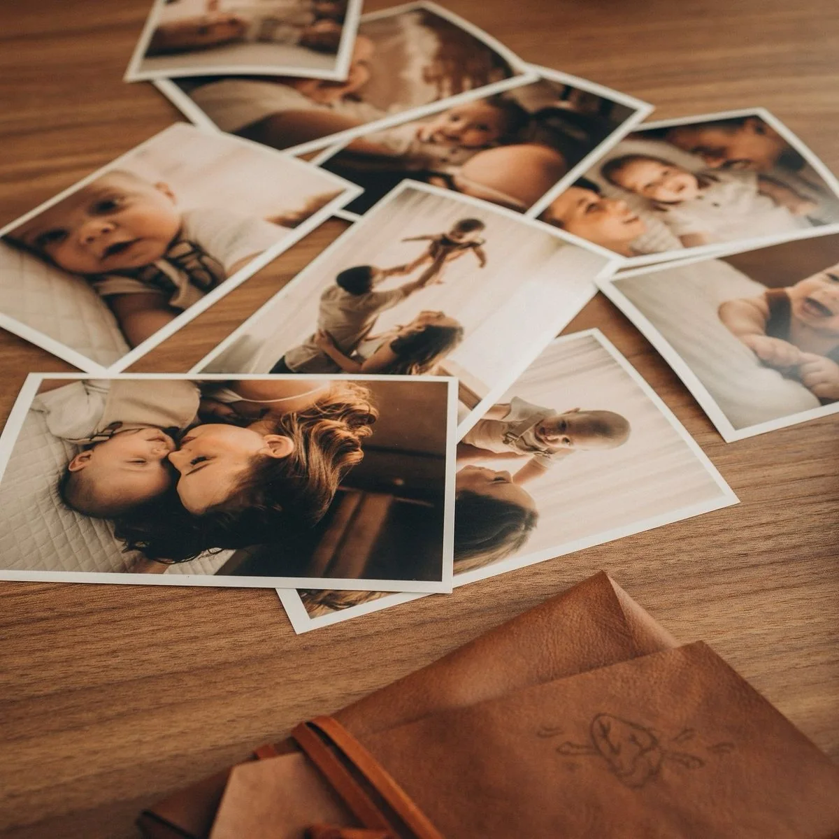 Polaroid-style photo prints scattered on a wooden table