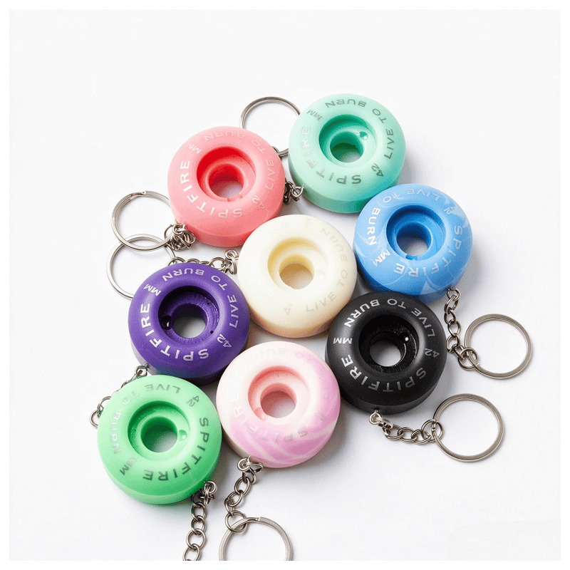 Assorted pastel spitfire wheel keychains piled together with metal rings and chains