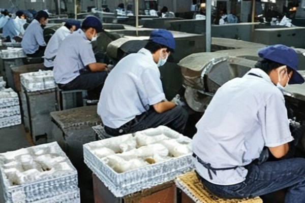Workers polishing and grinding die cast car keychains by hand