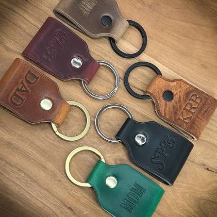 Colorful leather keychains in multiple shapes with initials embossed on each piece