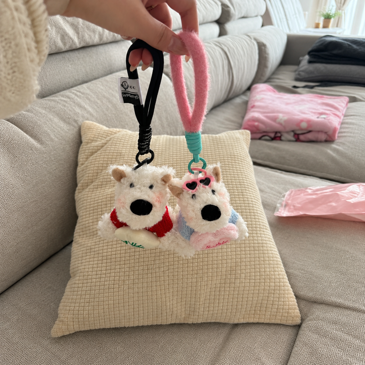 Pair of plush keychains with black and pink loop handles