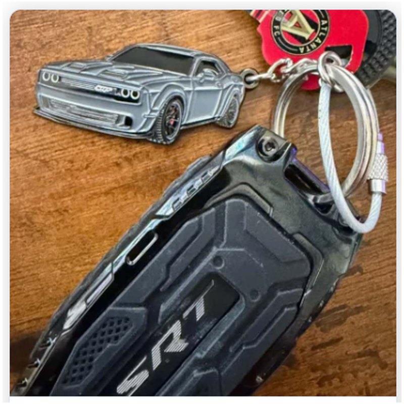 Gray muscle car keychain attached to a car key fob on a wooden table