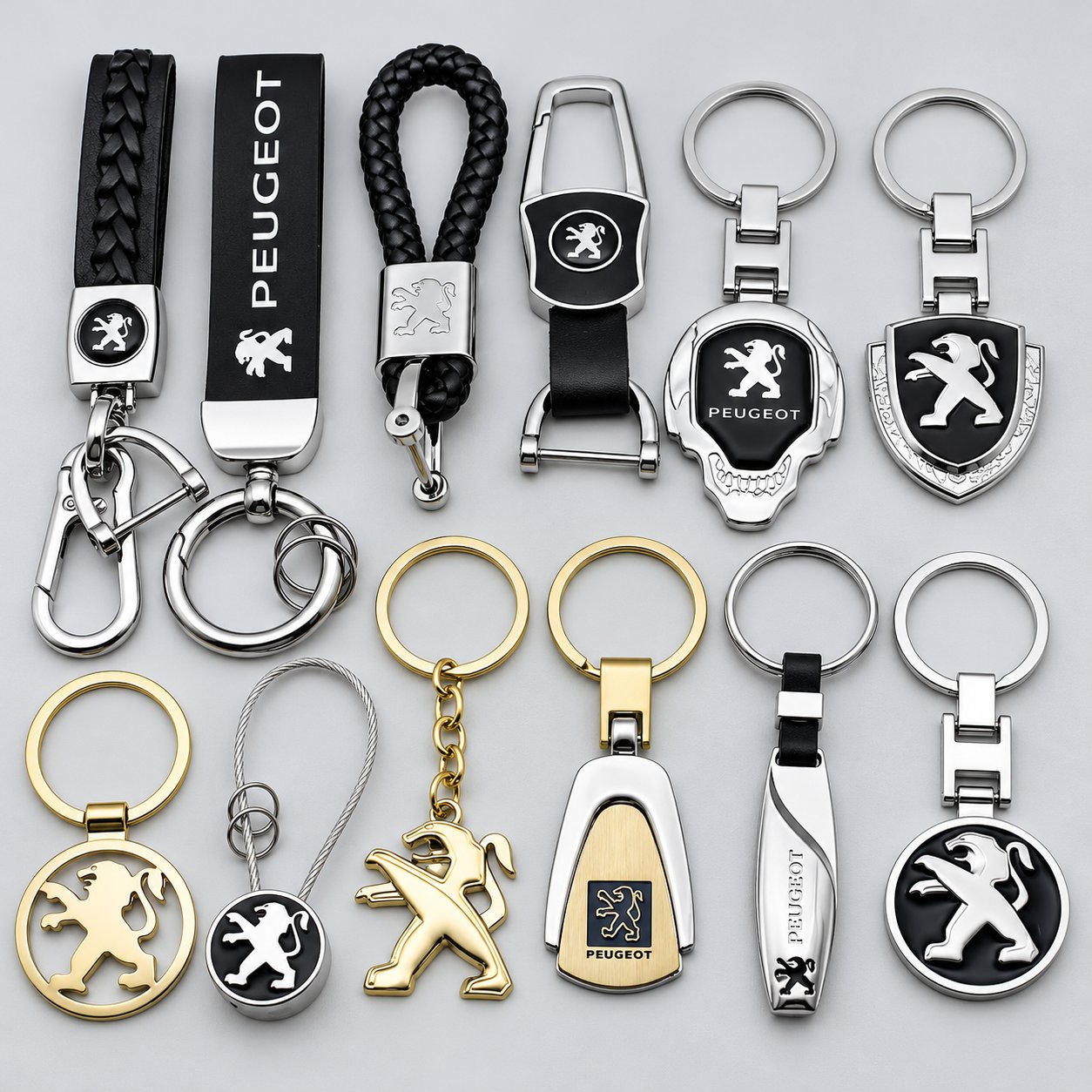 A collection of Peugeot branded metal car keychains in gold, silver and black finishes, in round, shield, tag and pendant shapes