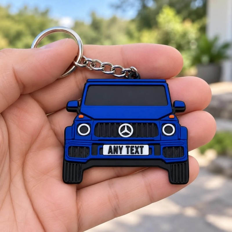 Blue PVC car keychain held in one hand outdoors