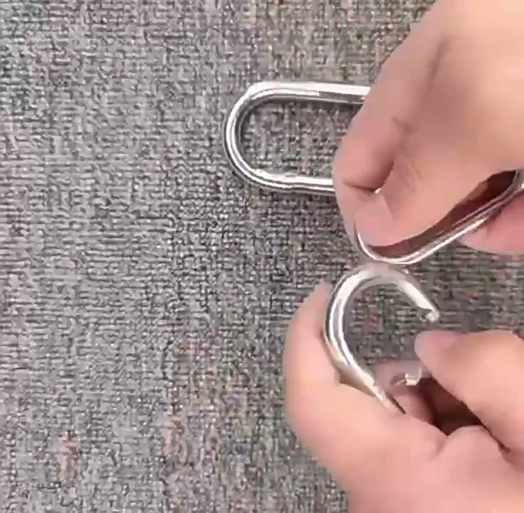 Spring loaded gate of a steel snap hook keychain opening under a thumb