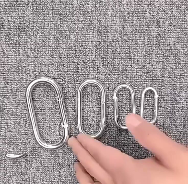 Steel snap hook keychains lined up from large to small on carpet