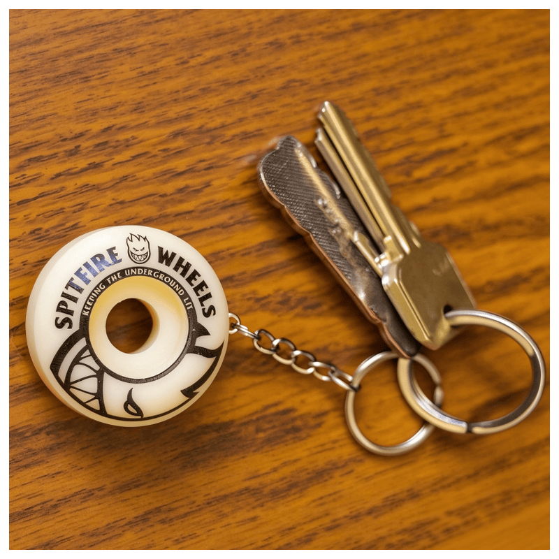 Spitfire wheel keychain attached to a set of house keys on a wooden table