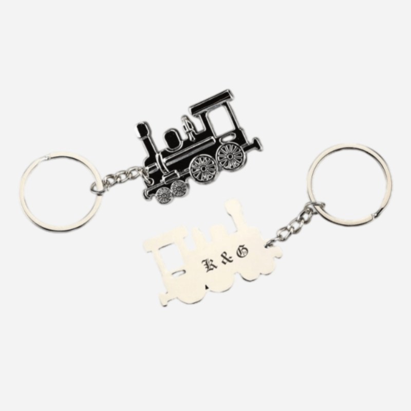 Matte black vintage train keychain beside a silver plate version with custom initials
